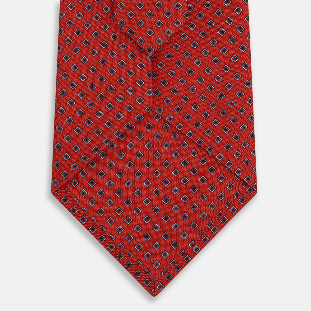 The Turnbull & Asser Red and Blue Square-Patterned Silk Tie is rolled up on a plain white background.