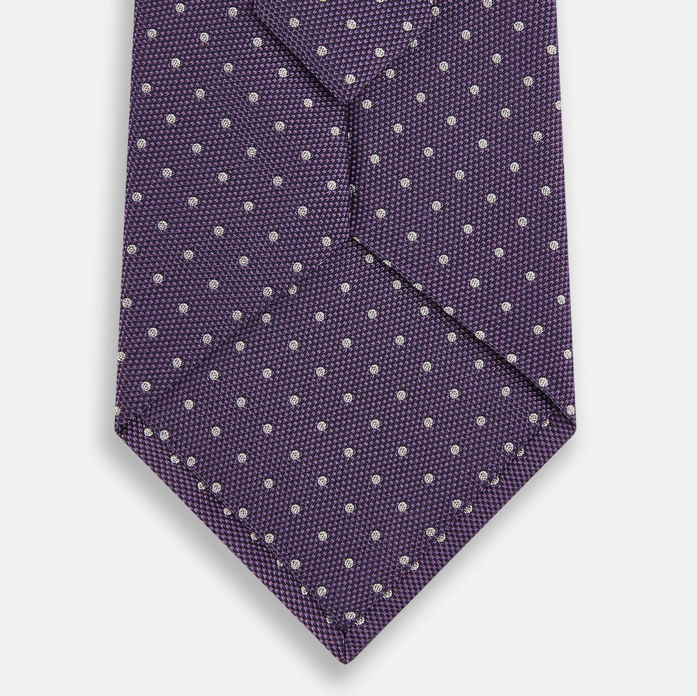The Turnbull & Asser Lavender and Purple Micro Dot Silk Tie is displayed rolled-up against a plain white background.