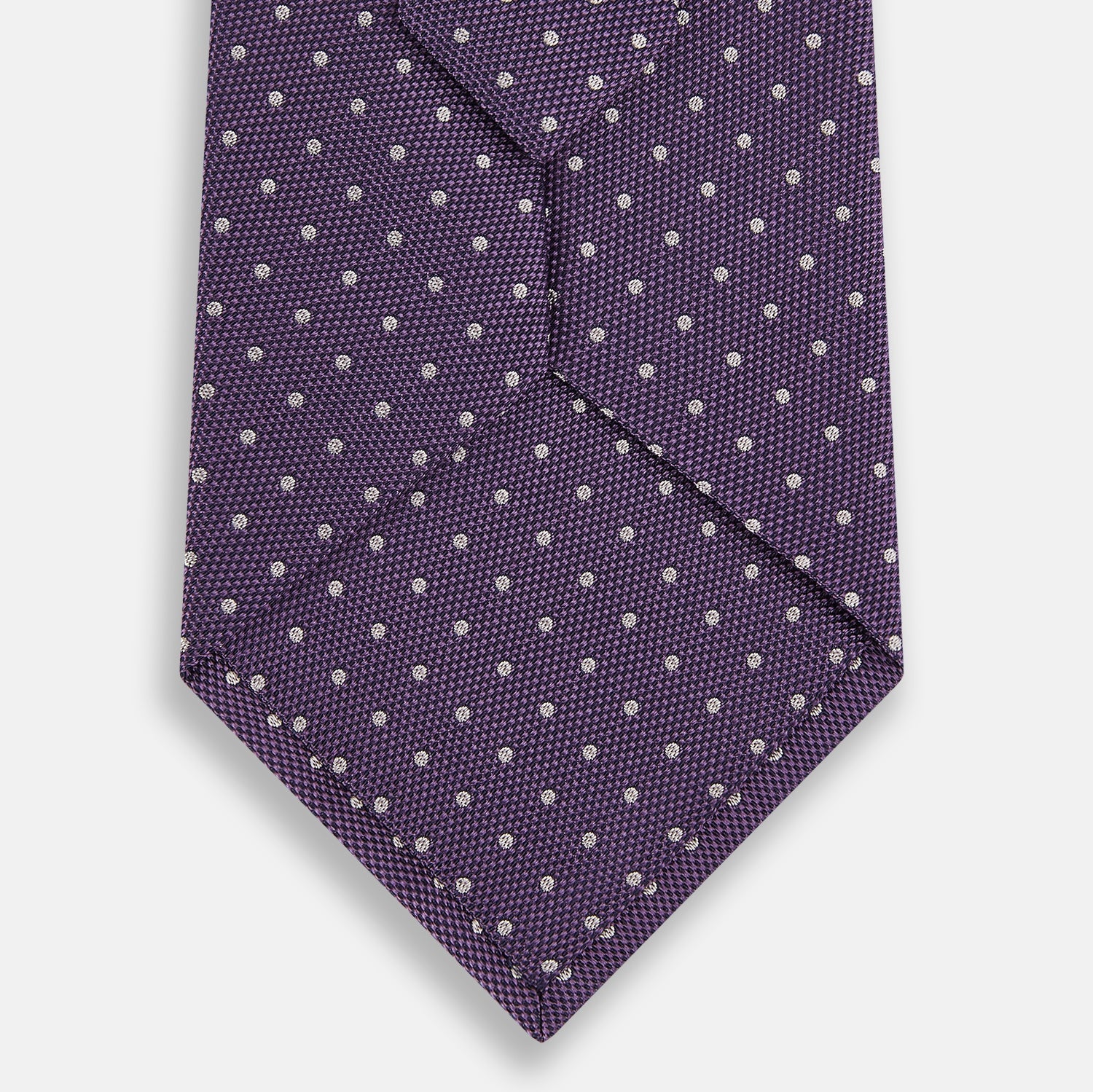 View 3 of product The Turnbull & Asser Lavender and Purple Micro Dot Silk Tie is displayed rolled-up against a plain white background.