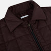 View 2 of product The Battersea Burgundy Quilted Jacket by Turnbull & Asser is a men's elegant outerwear featuring a front zipper, zippered side pockets, chest pocket, pointed collar, and buttoned cuffs, shown on a plain white background.