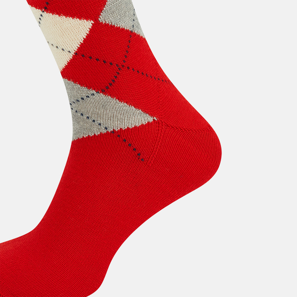 Mid-length orange wool socks by Turnbull & Asser, featuring a classic check pattern in orange, beige, and gray, reminiscent of timeless wool socks, displayed on a plain light background.