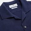 View 4 of product The Navy Silk Holiday Fit Phillips Shirt by Turnbull & Asser features short sleeves, a revere collar, and three front patch pockets, shown laid flat on a white background.