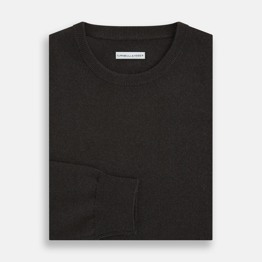A plain, long-sleeved brown cashmere round neck jumper by Turnbull & Asser displayed on a white background. This men’s knitwear features ribbed cuffs, hem, and neckline with a relaxed fit and no visible patterns or logos.