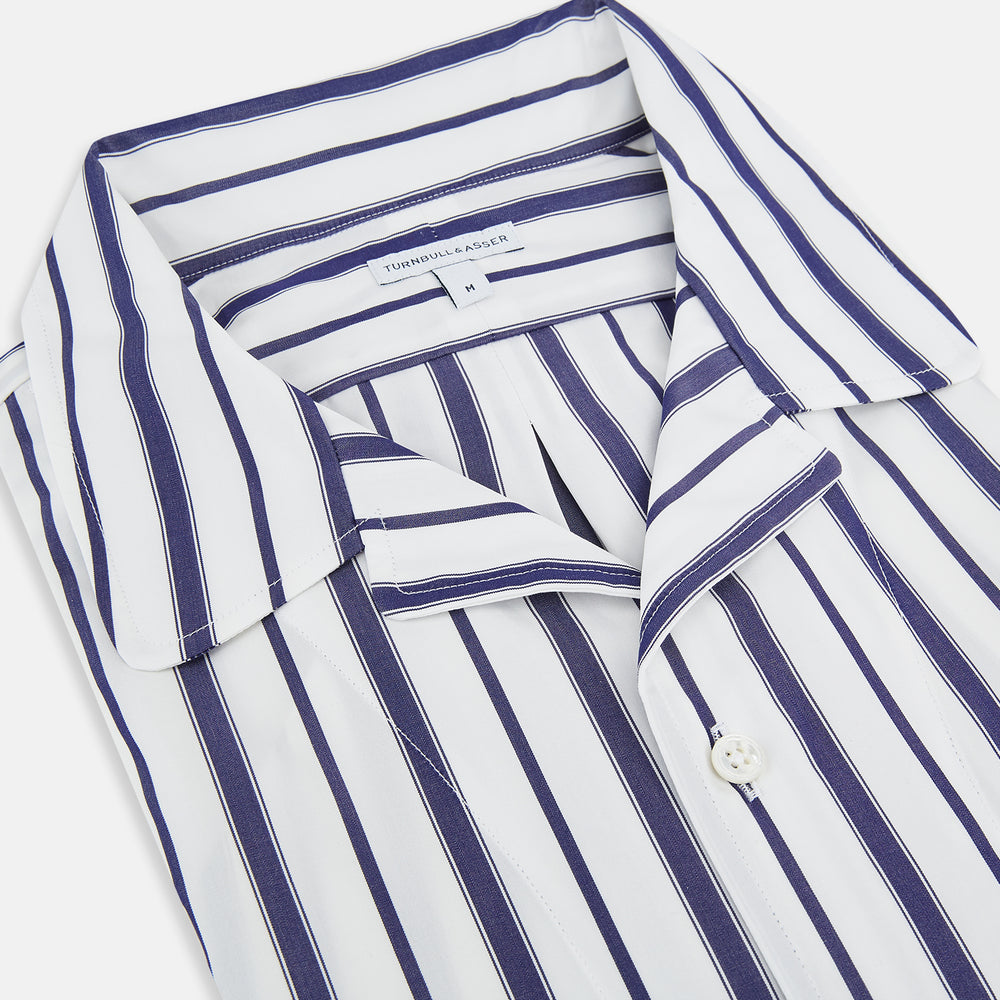 The Turnbull & Asser Navy Double Stripe Quarzo Nightshirt, a knee-length Italian cotton nightshirt with navy and white vertical stripes, collar, chest pocket, and button-down front, is displayed flat on a white background.
