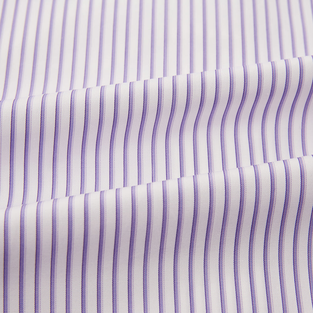 The Turnbull & Asser Purple Shadow Stripe Mayfair Shirt features a long-sleeve button-up design with thin vertical blue and white stripes, a T&A collar, and buttoned cuffs, shown on a plain white background.