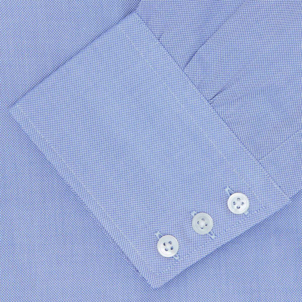 View 3 of product The Turnbull & Asser Blue Royal Oxford Cotton Shirt features a button-down collar, 3-button cuffs, and a visible brand label, shown neatly folded on a white background—ideal for pairing with a navy suit.