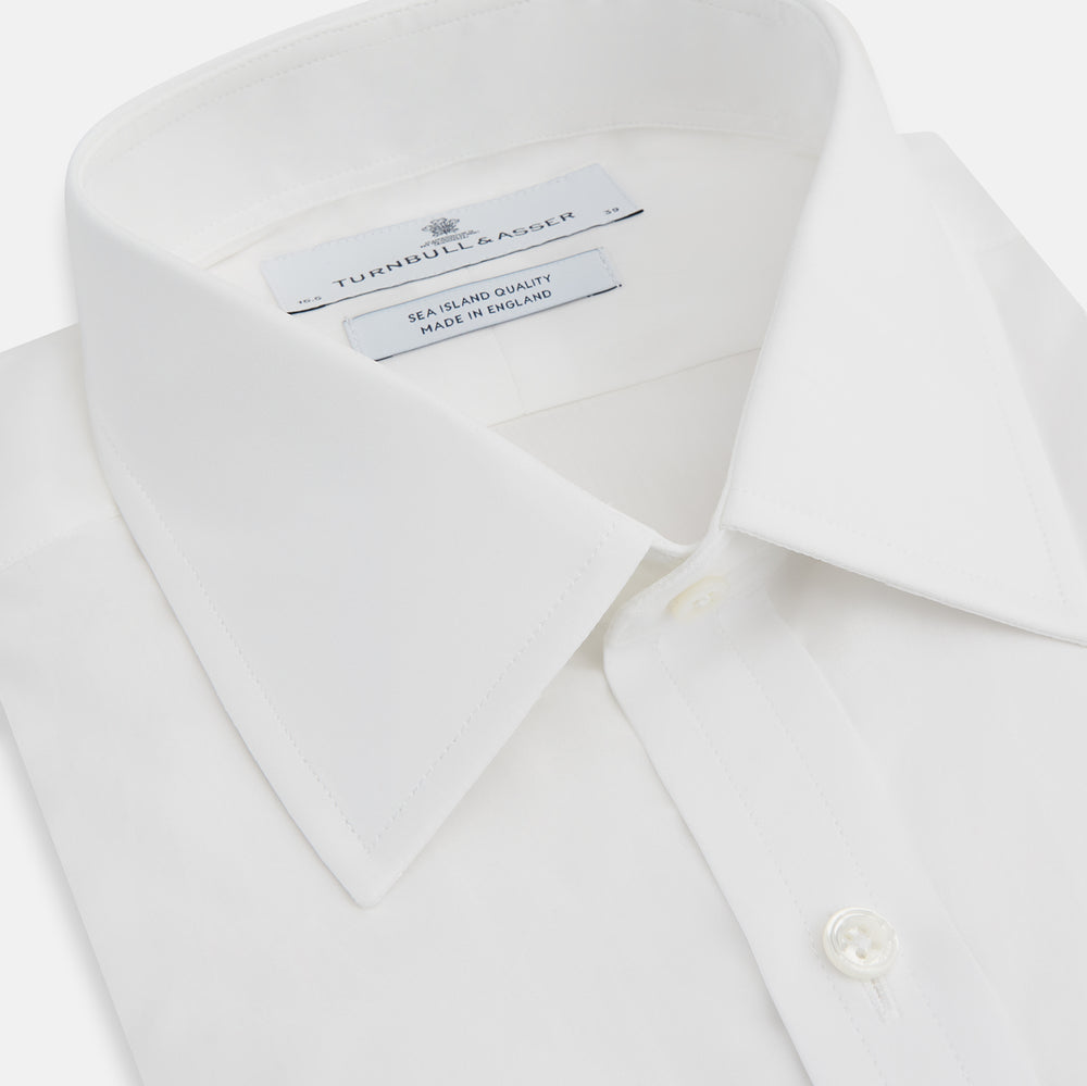 The Turnbull & Asser White Sea Island Quality Cotton Shirt features a T&A collar, double cuffs, and long sleeves, displayed against a white background.