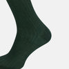 View 4 of product The Turnbull & Asser Olive Long Socks, featuring a ribbed texture, are shown over the calf on a plain white background—a refined addition to any men’s dress sock collection.