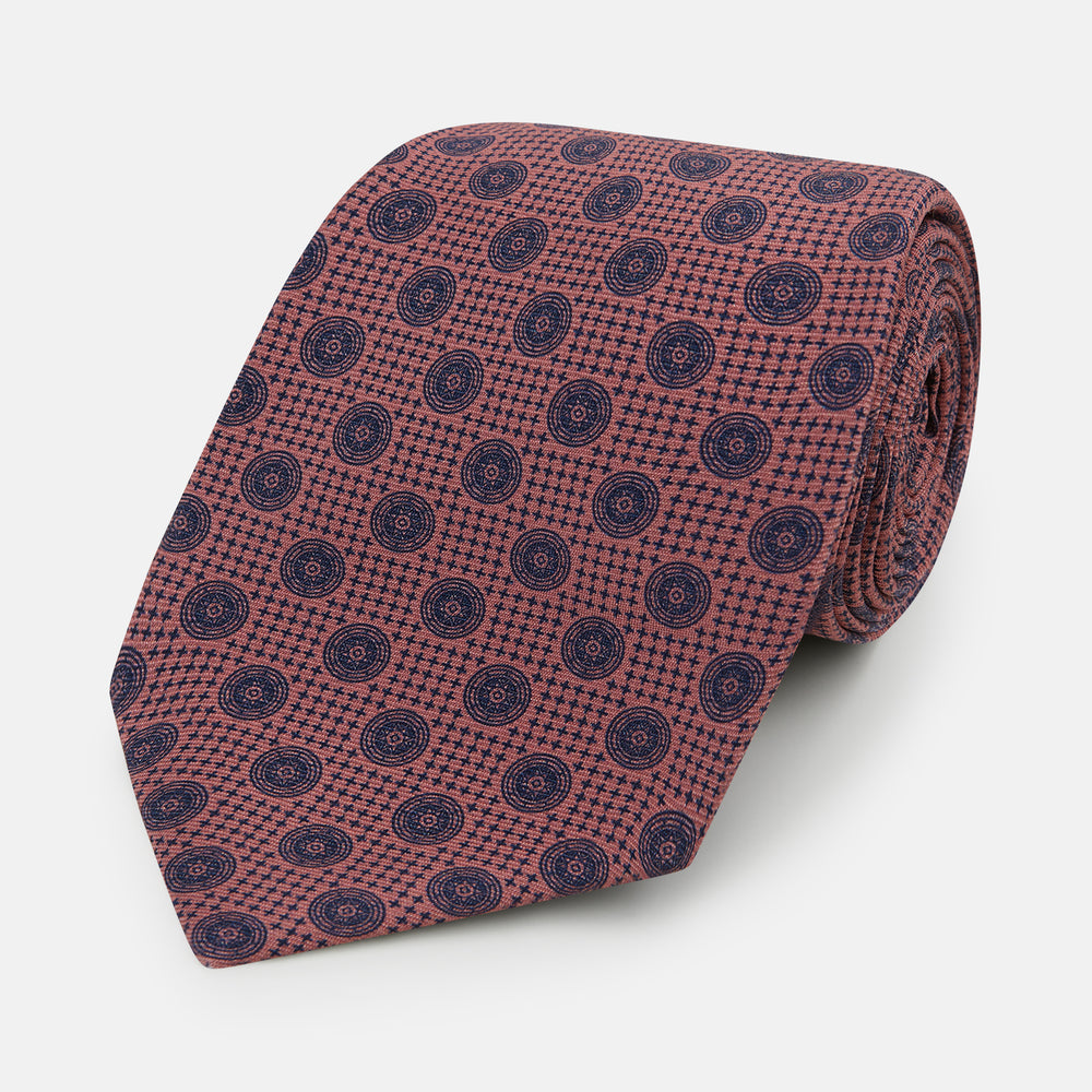 The Antique Pink Medallion Silk Tie by Turnbull & Asser is a men's luxury accessory, crafted from English silk in antique pink and detailed with small navy blue medallion motifs.