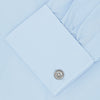 View 3 of product The Turnbull & Asser Light Blue Sea Island Quality Cotton Shirt features a T&A collar, double cuffs, white buttons, and a quality label inside the collar. Displayed on a plain white background.