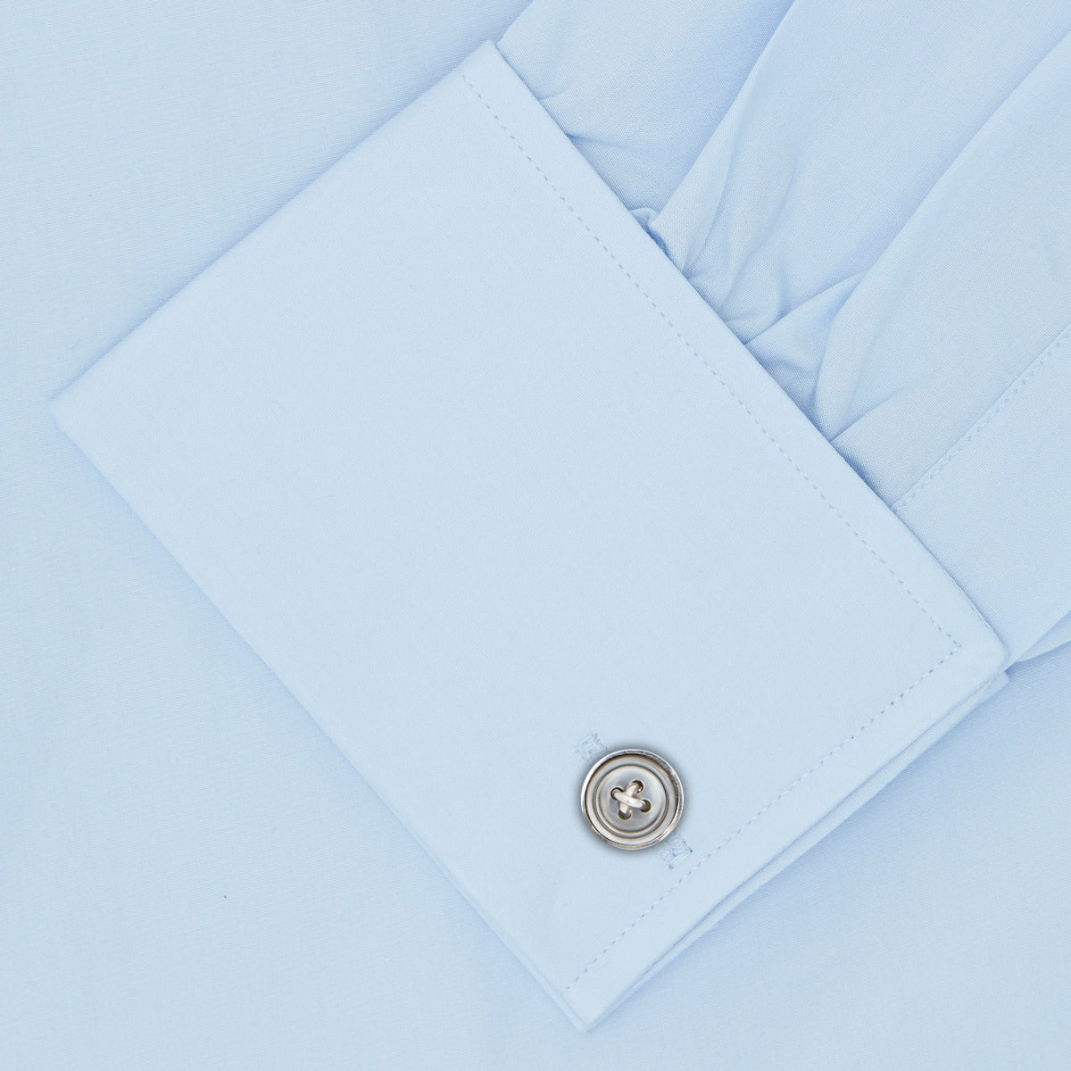 View 3 of product The Turnbull & Asser Light Blue Sea Island Quality Cotton Shirt features a T&A collar, double cuffs, white buttons, and a quality label inside the collar. Displayed on a plain white background.