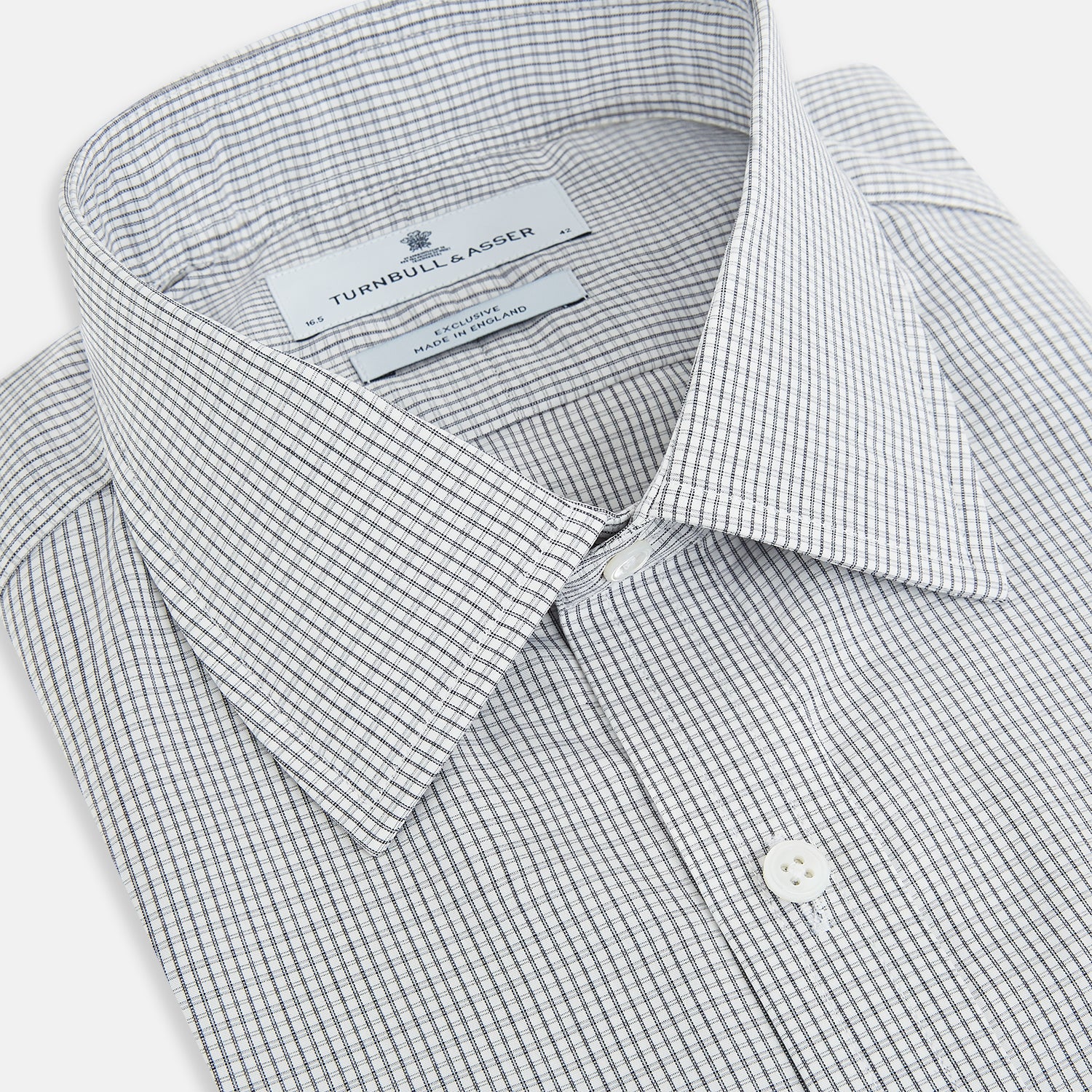 View 2 of product The Midnight Blue Micro Tattersall Check Mayfair Shirt by Turnbull & Asser, made from pure cotton with white buttons, a classic collar, and cuffed sleeves, is laid flat on a white background.