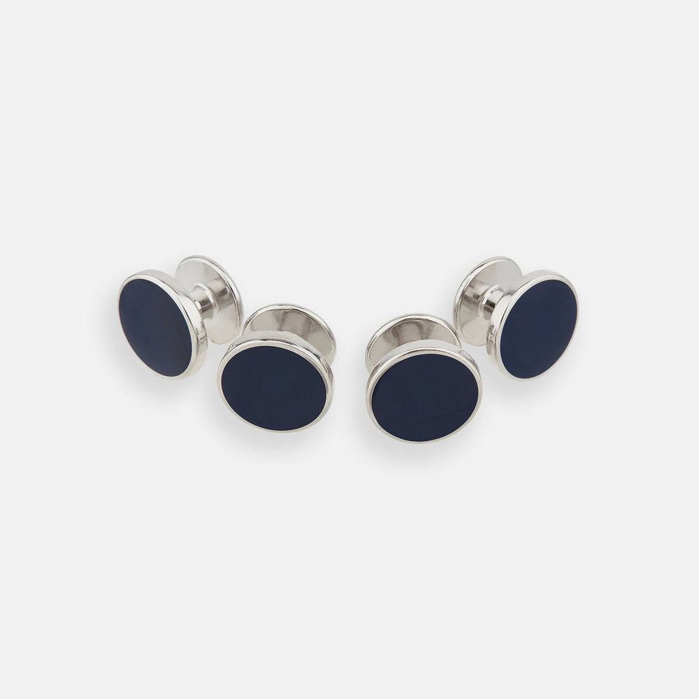 Turnbull & Asser's Navy Circle Dress Studs, a set of four sterling silver cufflinks with dark blue oval faces, are the ideal gentleman's accessory—timelessly sophisticated and perfect for elevating any formal look.
