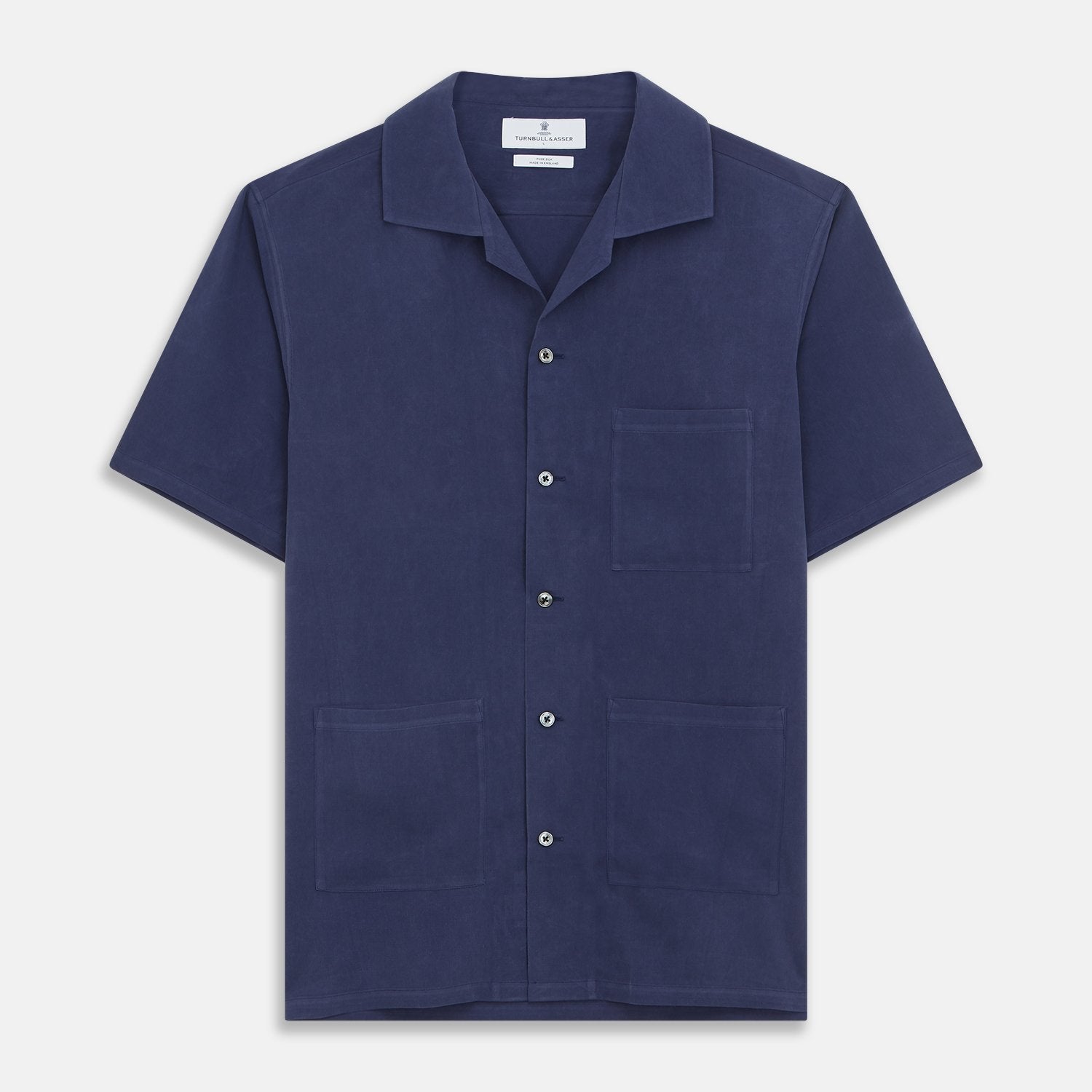 View 2 of product The Navy Silk Holiday Fit Phillips Shirt by Turnbull & Asser features short sleeves, a revere collar, and three front patch pockets, shown laid flat on a white background.