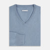 View 4 of product The Turnbull & Asser Frost Blue Cashmere V-Neck Jumper features ribbed cuffs, hem, and neckline. This elegant long sleeve knitwear piece is shown on a plain white background.