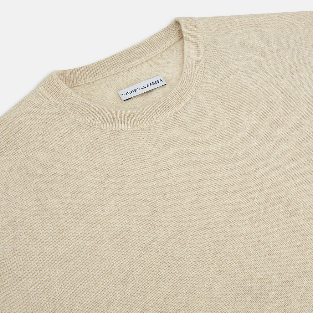 The Turnbull & Asser Cream Cashmere Round Neck Jumper features long sleeves, ribbed cuffs, and a ribbed hem—a versatile men’s knitwear staple, shown against a white background.
