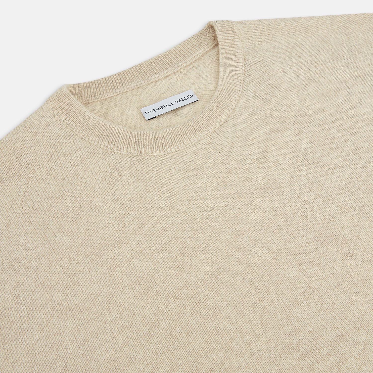 View 2 of product The Turnbull & Asser Cream Cashmere Round Neck Jumper features long sleeves, ribbed cuffs, and a ribbed hem—a versatile men’s knitwear staple, shown against a white background.