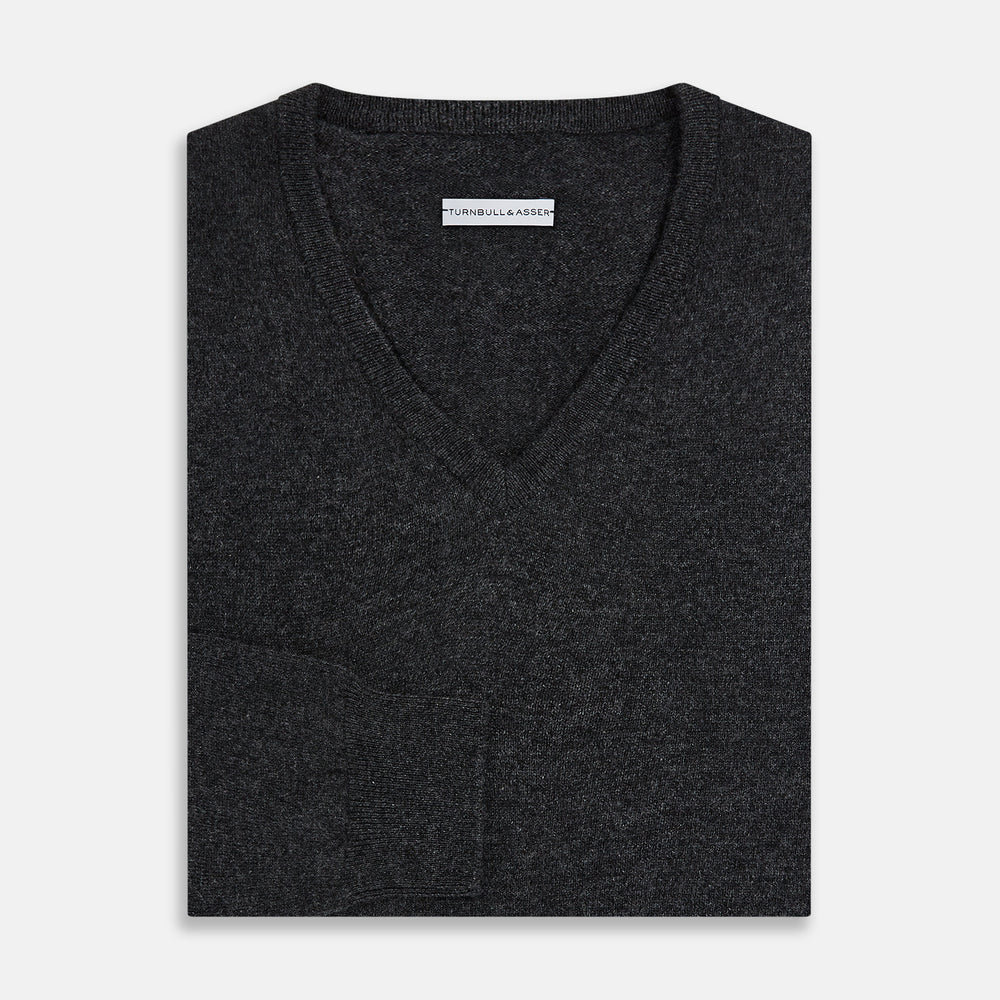 The Turnbull & Asser Charcoal Grey Melange V-Neck Cashmere Jumper is shown on a white background, featuring long sleeves, ribbed cuffs and hem for classic style and comfort.