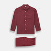 View 1 of product The Turnbull & Asser Burgundy Silk Pyjama Set features a long-sleeve, button-up shirt with chest pocket and matching pants with elastic waistband and side pocket, shown on a white background.