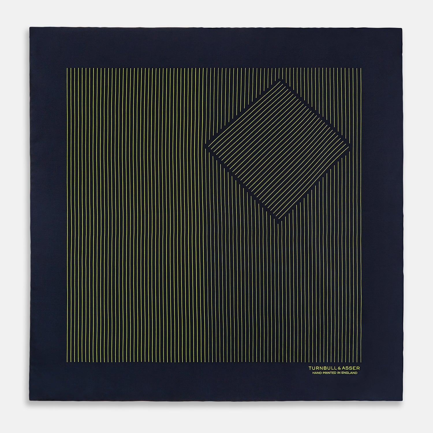 View 3 of product Turnbull & Asser Navy and Yellow Stripe Silk Pocket Square features hand-rolled edges, striped pattern, and "Turnbull & Asser Hand Printed in England" text in yellow on the bottom right corner.