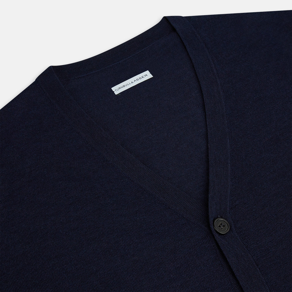 The Turnbull & Asser Navy Fine Merino V-Neck Cardigan features long sleeves, ribbed cuffs and hem, and is crafted from premium yarn for comfort and style, shown on a white background.