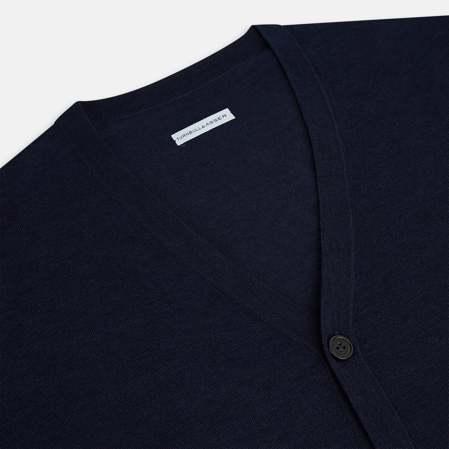 View 2 of product The Turnbull & Asser Navy Fine Merino V-Neck Cardigan features long sleeves, ribbed cuffs and hem, and is crafted from premium yarn for comfort and style, shown on a white background.