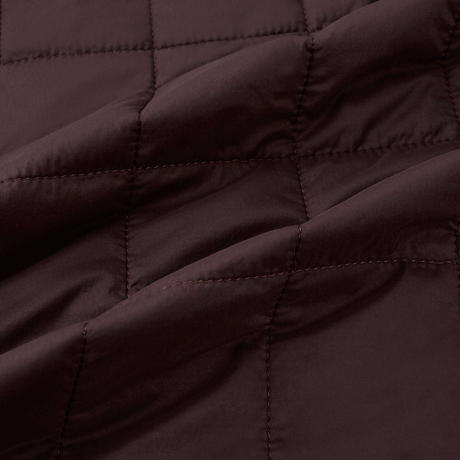 View 4 of product The Turnbull & Asser Burgundy Quilted Gilet is a sleeveless, lightweight layer featuring a front zipper, slanted chest pocket, adjustable side tabs, and two zippered side pockets, shown on a plain white background.