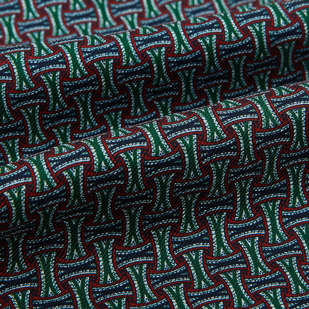 The Forest Green and Red Weave Patterned Silk Cravat by Turnbull & Asser features an elegant geometric design in rich hues, folded to a pointed end for a classic, British-inspired look.