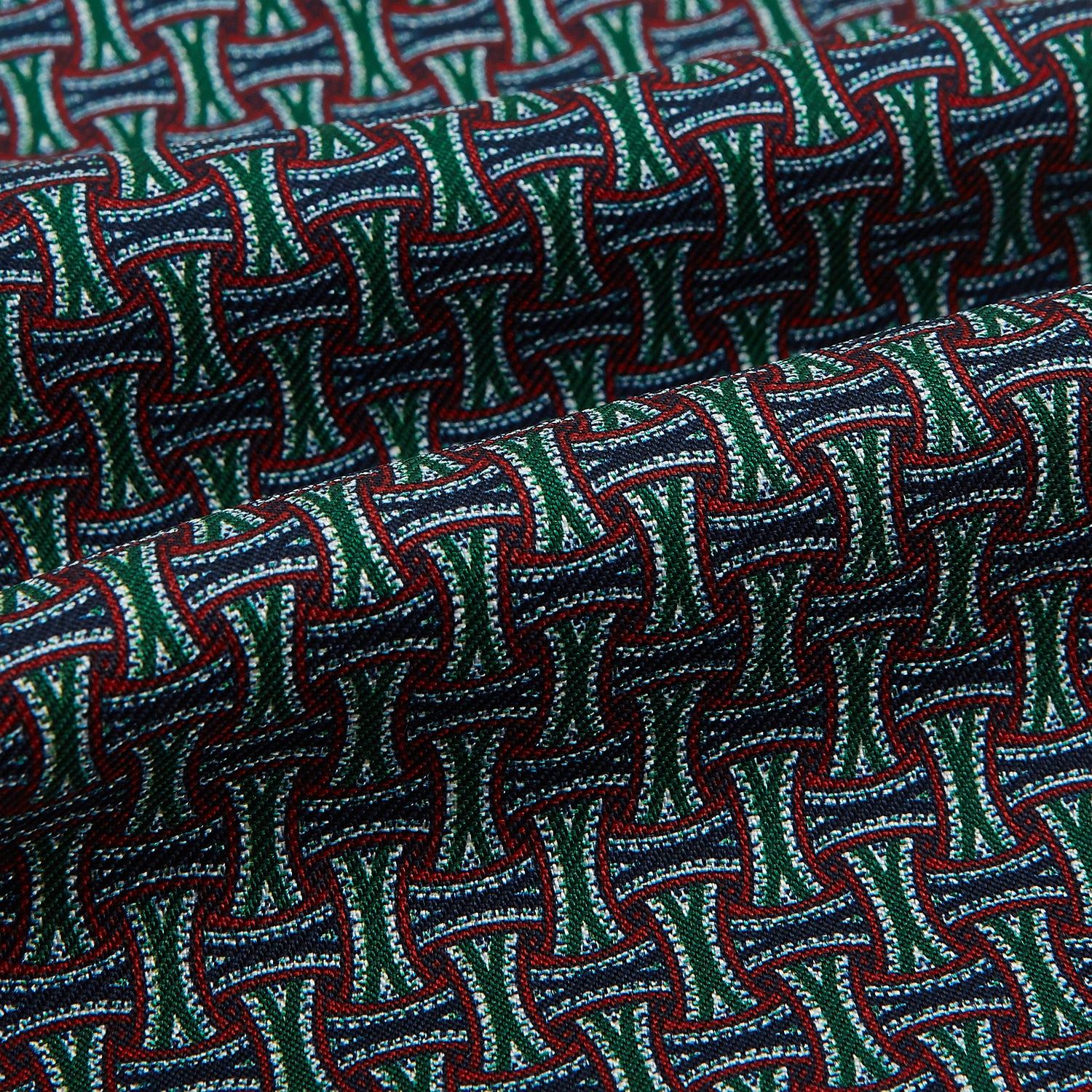 View 4 of product The Forest Green and Red Weave Patterned Silk Cravat by Turnbull & Asser features an elegant geometric design in rich hues, folded to a pointed end for a classic, British-inspired look.