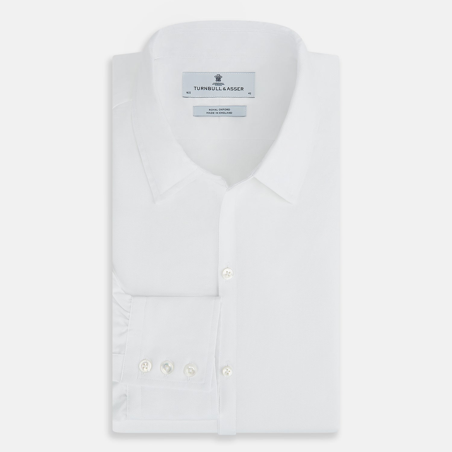 View 5 of product The Turnbull & Asser White Royal Oxford Cotton Windsor Shirt features a Turnbull open collar, long sleeves, 3-button cuffs, and a straight hem, shown against a plain white background.