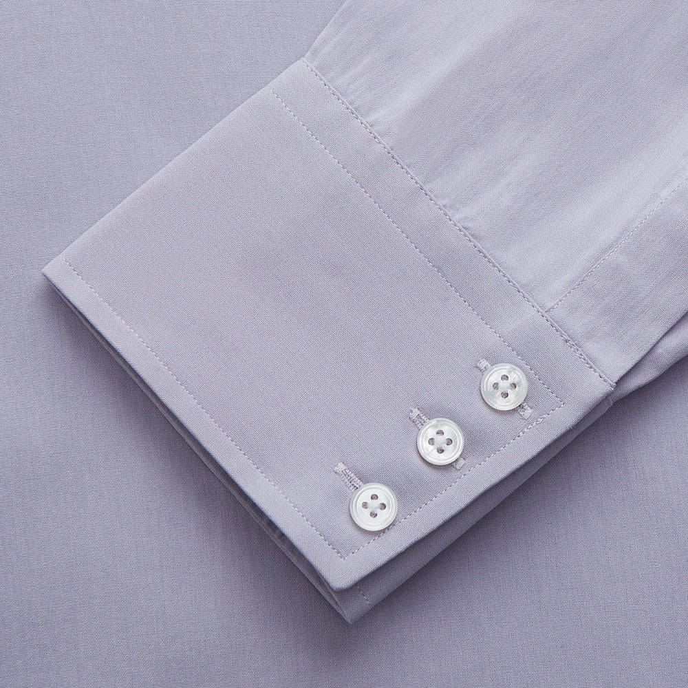 The Turnbull & Asser Lilac Silk Regular Fit Flaxton Shirt features long sleeves, a classic collar, white buttons, and a curved hem, shown laid flat on a white background.