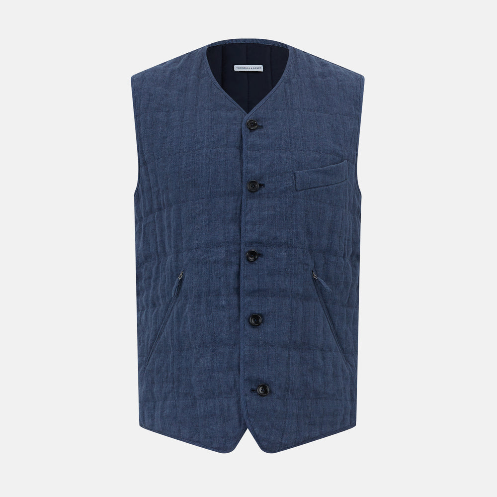 The Denim Blue Quilted Linen Herringbone Waistcoat by Turnbull & Asser features a sleeveless design, five black buttons, two zippered side pockets, and a small chest pocket against a plain white background.