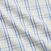View 4 of product The Turnbull & Asser Cream Multi Cotton Sussex Nightshirt is a knee-length, long-sleeve shirt dress with a blue and beige plaid pattern, collar, front button placket, chest pocket, and rounded hem with side slits.