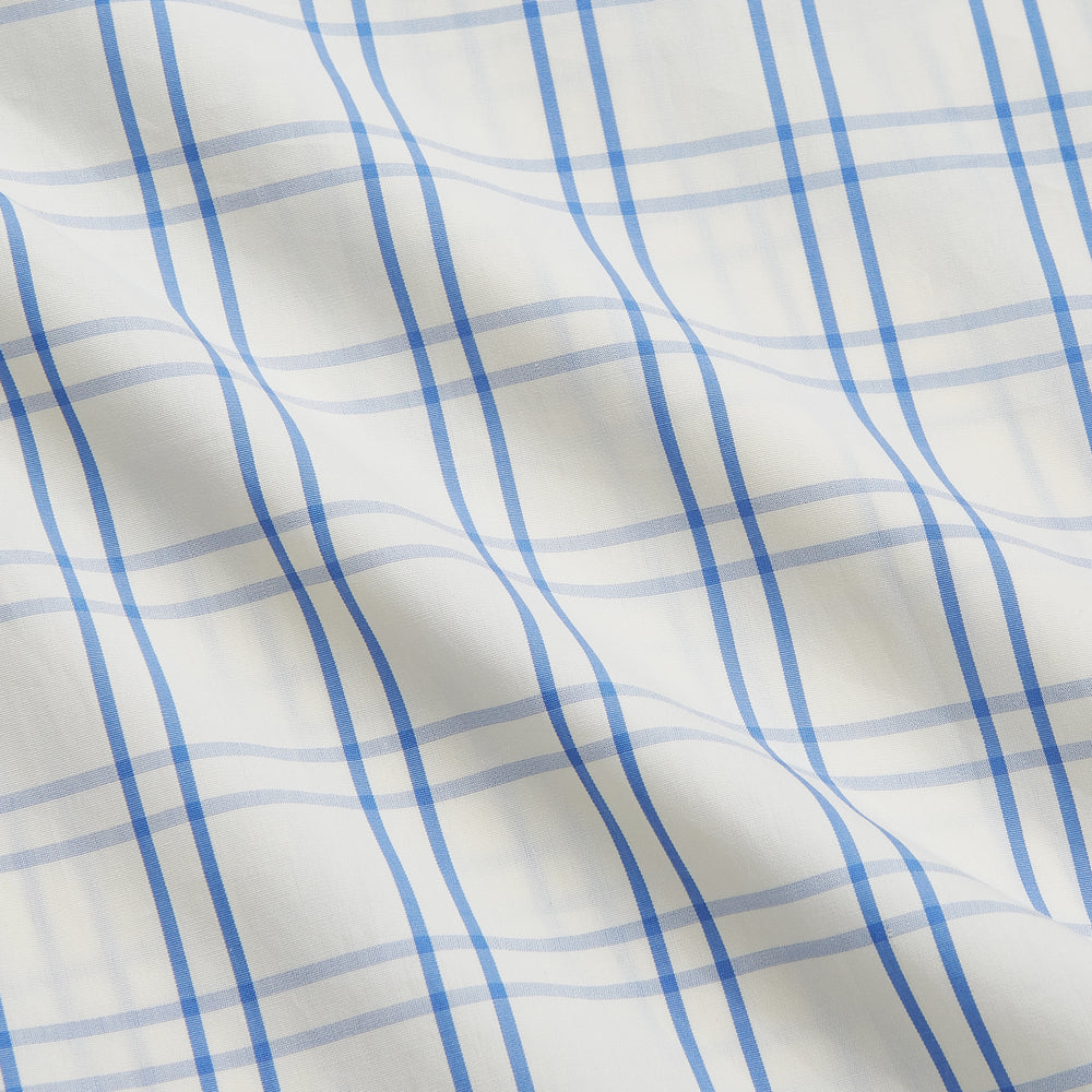 The Turnbull & Asser Cream Multi Cotton Sussex Nightshirt is a knee-length, long-sleeve shirt dress with a blue and beige plaid pattern, collar, front button placket, chest pocket, and rounded hem with side slits.