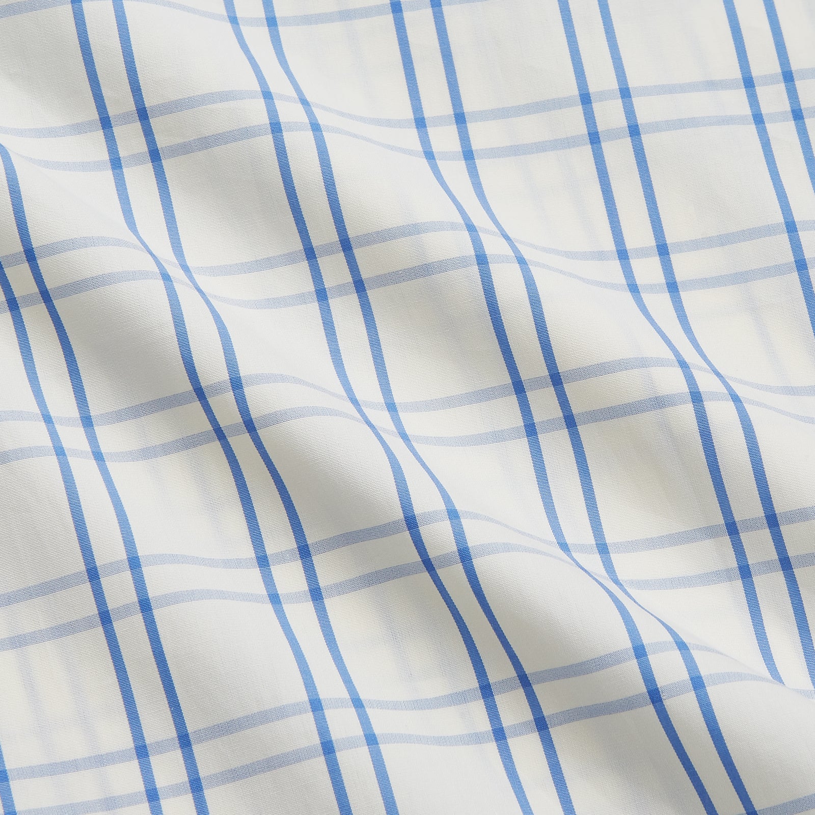View 4 of product The Turnbull & Asser Cream Multi Cotton Sussex Nightshirt is a knee-length, long-sleeve shirt dress with a blue and beige plaid pattern, collar, front button placket, chest pocket, and rounded hem with side slits.