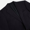 View 2 of product The Turnbull & Asser Short Navy Single Breasted Suit is shown flat on a white background, with a notch lapel jacket featuring two front pockets and matching trousers neatly folded underneath.