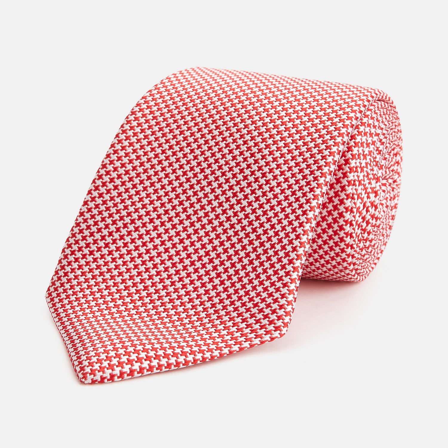 View 1 of product The HOUNDSTOOTH WHITE TULIP RED TIE by Turnbull & Asser features a refined red and white houndstooth pattern—an elegant accessory that elevates any crisp shirt or formal look.