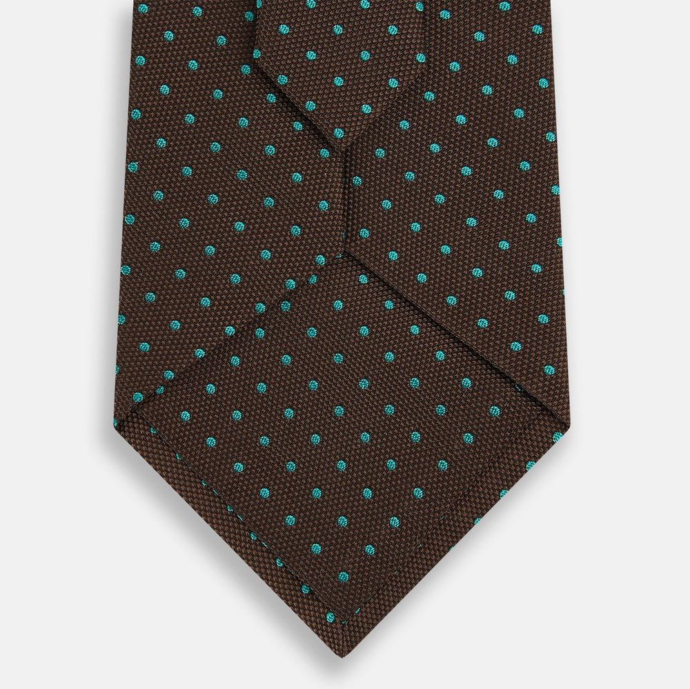 The Turnbull & Asser Green and Brown Micro Dot Silk Tie is shown rolled up, displaying its evenly spaced micro dot pattern against a plain white background.