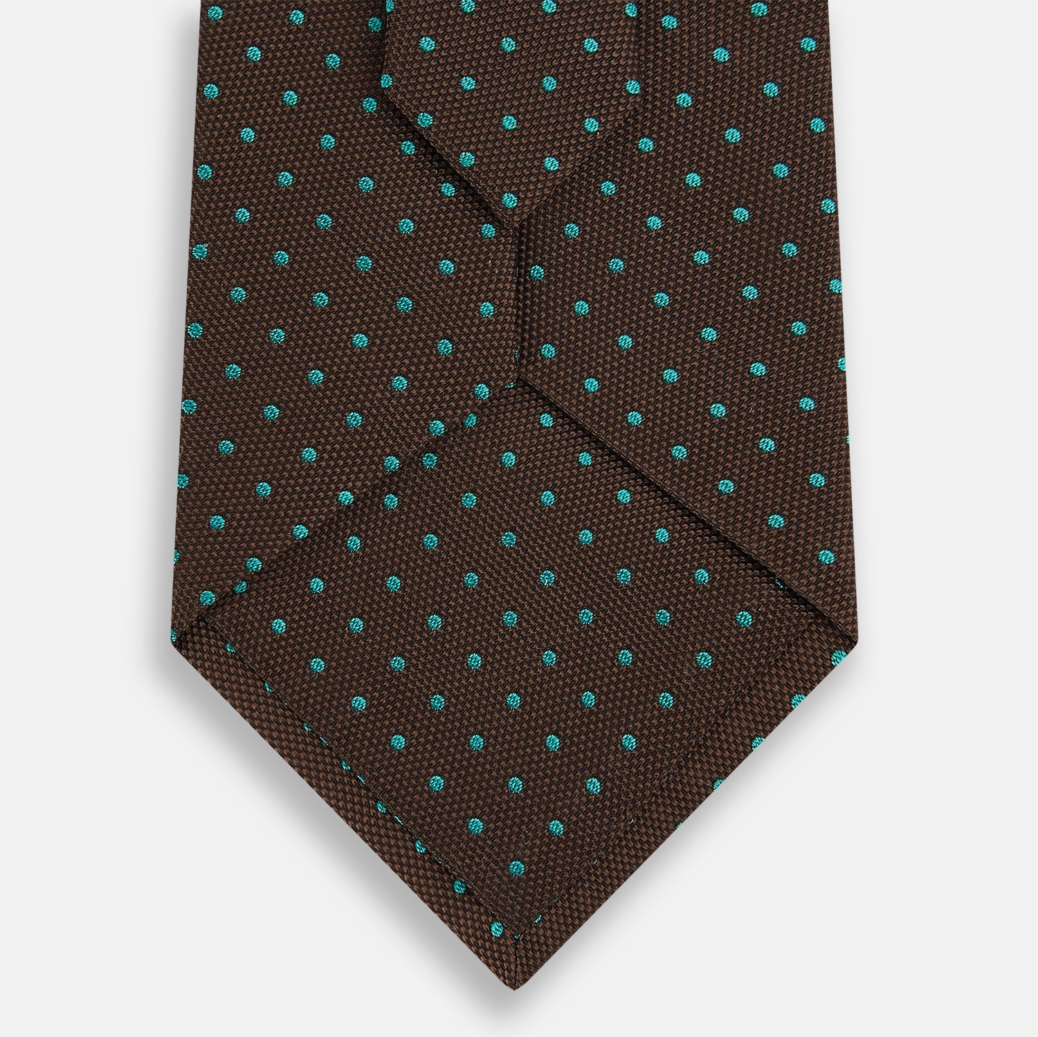 View 3 of product The Turnbull & Asser Green and Brown Micro Dot Silk Tie is shown rolled up, displaying its evenly spaced micro dot pattern against a plain white background.