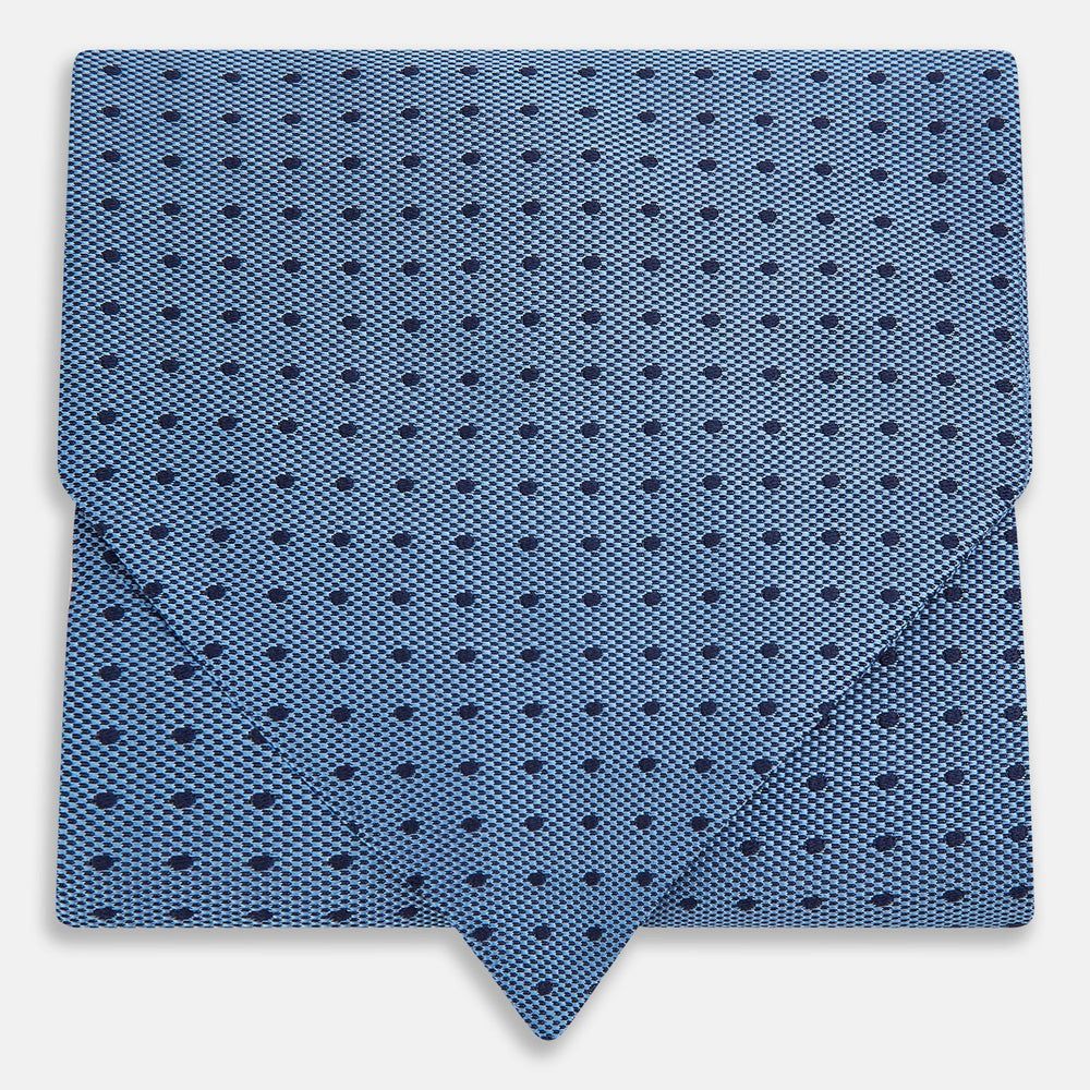 The Turnbull & Asser Navy and Blue Micro Dot Silk Cravat, featuring a refined dot pattern, makes an elegant statement when paired with a matching pocket square, showcased here against a white background.