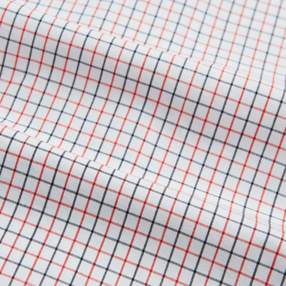 Turnbull & Asser’s Hand Rolled Red and Navy Graph Check Handkerchief—a white cotton accessory with red and navy grid lines, neatly folded for a touch of refined elegance.