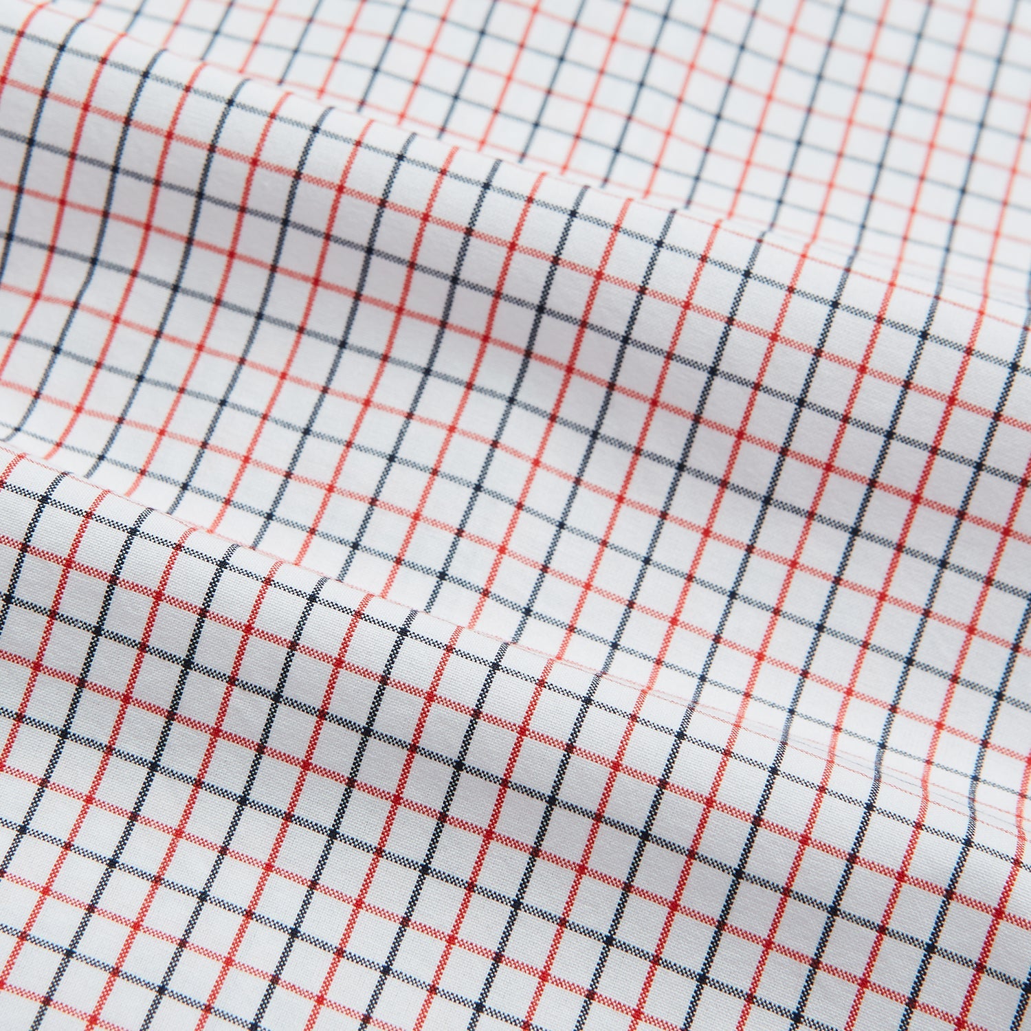 View 4 of product Turnbull & Asser’s Hand Rolled Red and Navy Graph Check Handkerchief—a white cotton accessory with red and navy grid lines, neatly folded for a touch of refined elegance.