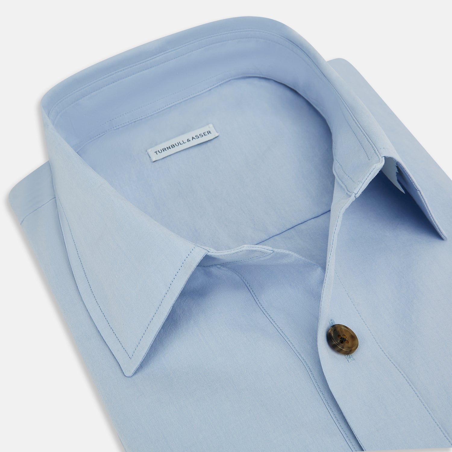 View 2 of product The Turnbull & Asser Pale Blue Hyde Overshirt is a long-sleeve, sanforised cotton button-up with a single chest pocket and dark buttons, shown on a plain white background.