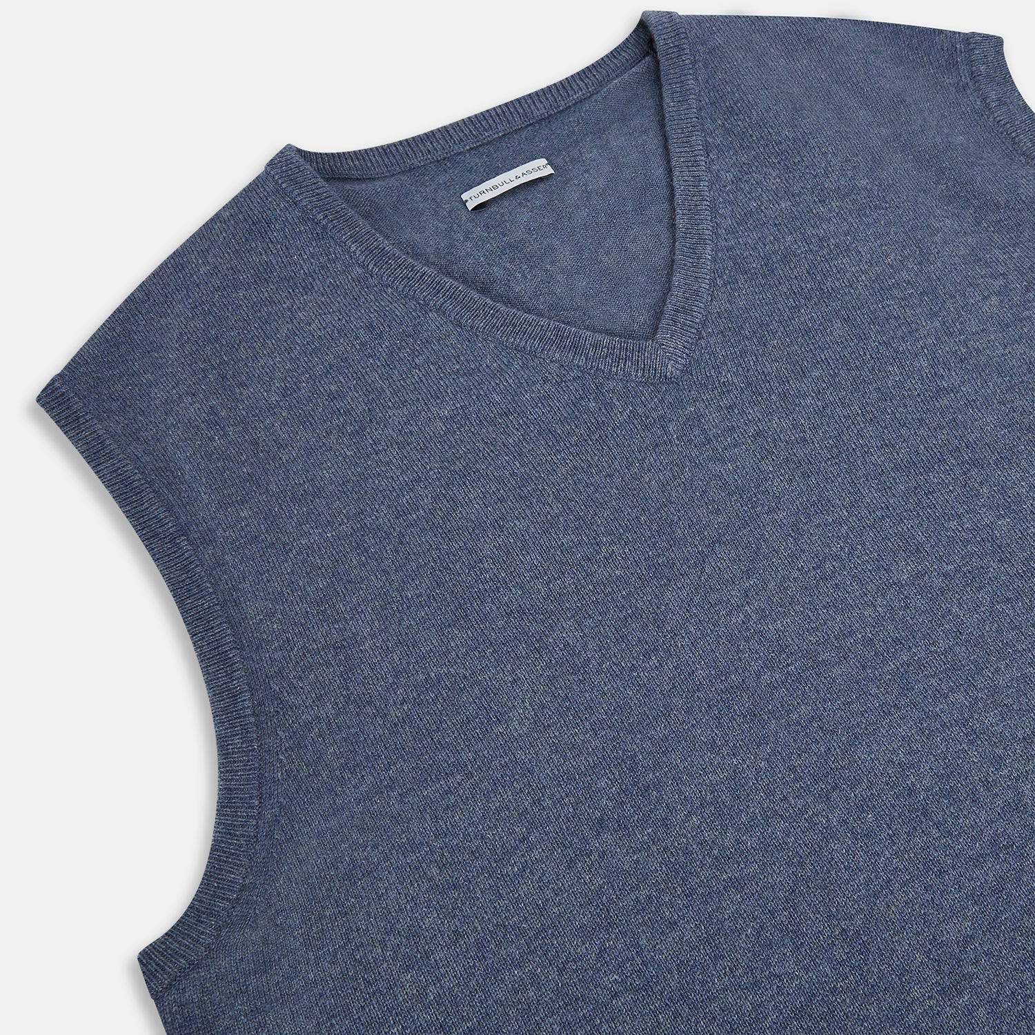View 2 of product The Avio Blue Cashmere V-neck Vest by Turnbull & Asser is a sleeveless knitwear piece with ribbed hem and armholes, shown against a plain white background.