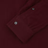 View 3 of product The Turnbull & Asser Burgundy Cashmerello Button Down Shirt features long sleeves, buttoned chest pockets, a spread collar, and is crafted from a soft cotton-cashmere blend, neatly displayed on a plain white background.