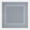 View 9 of product The Turnbull & Asser Grey Dot Silk Pocket Square features a light gray silk design with navy polka dots and a solid border. Elegantly handmade, it is shown with one corner folded to display both sides.