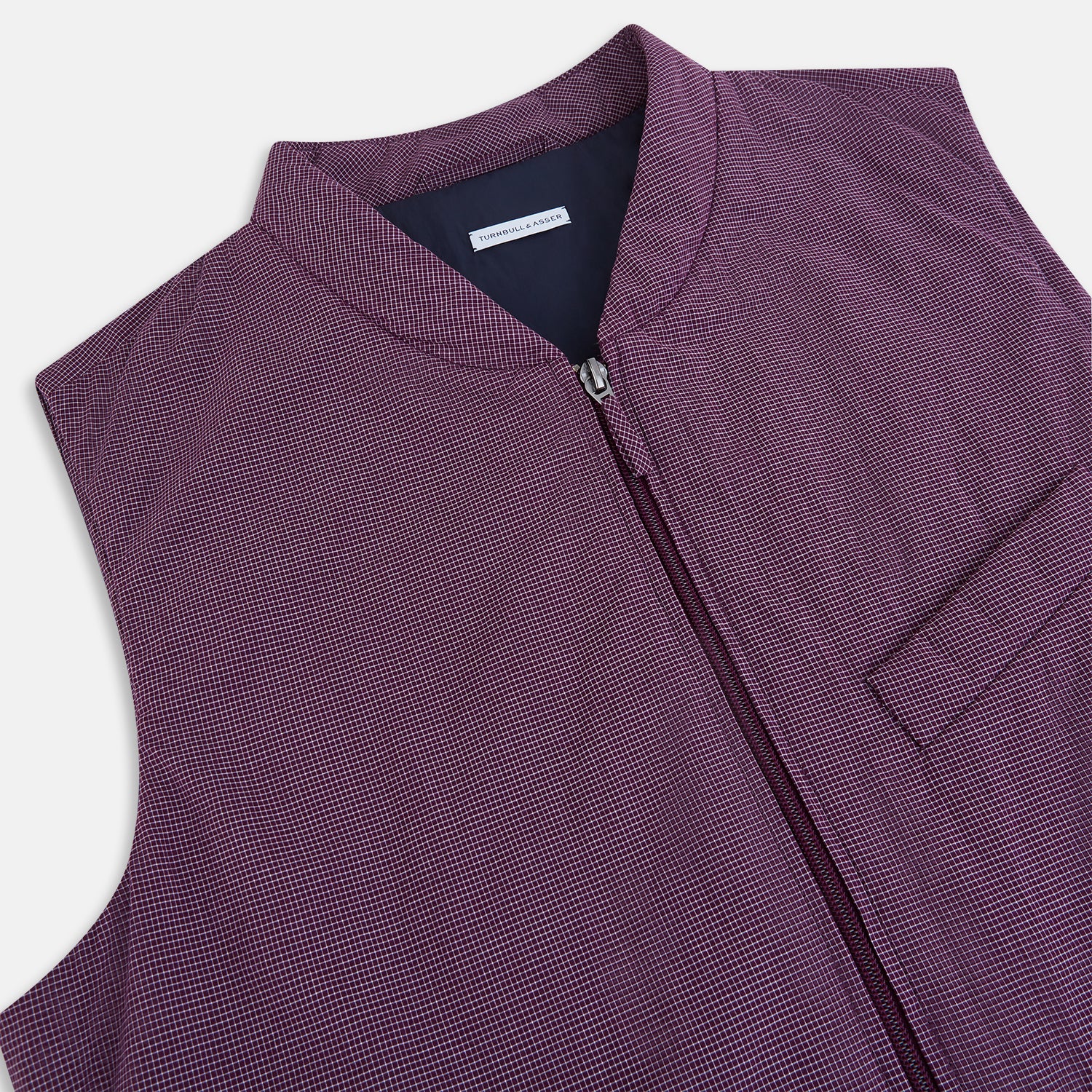 View 2 of product The Turnbull & Asser Burgundy Pin Check Padded Gilet features a front zipper, two zippered side pockets, a chest pocket, and a rounded hem—an ideal men’s layering piece shown on a white background.