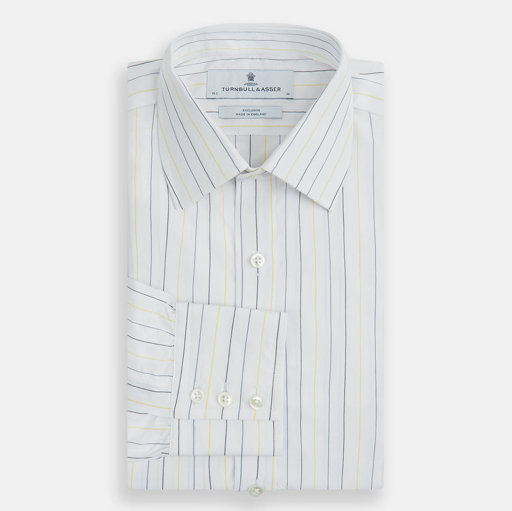 The Navy and Yellow Wide Pinstripe Mayfair Shirt by Turnbull & Asser is a long-sleeve, button-up shirt with wide navy and yellow pinstripes, a collar, and buttoned cuffs, laid flat on a white surface.