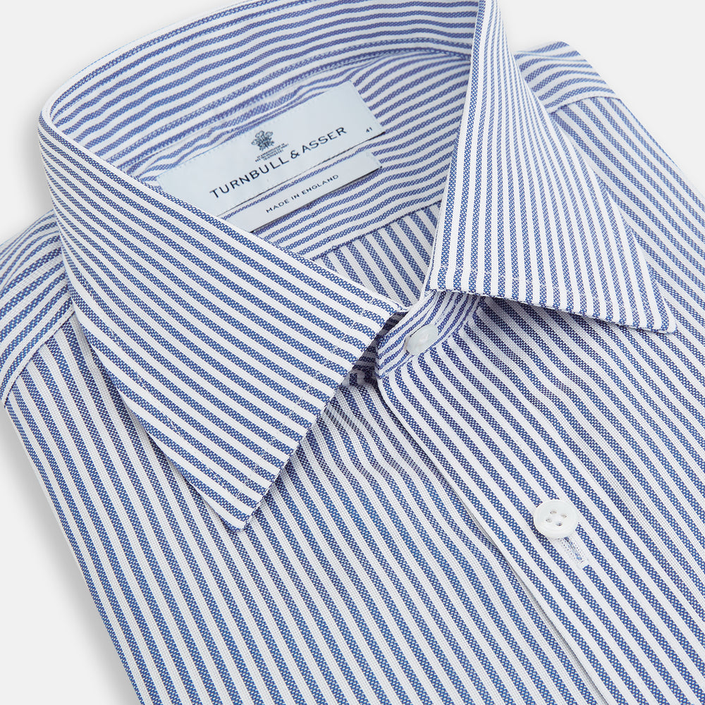 The Turnbull & Asser Navy Bengal Stripe Mayfair Shirt is a long-sleeved, collared formal shirt with blue and white stripes, white buttons, and buttoned cuffs—ideal for classic style enthusiasts. Displayed on a plain white background.