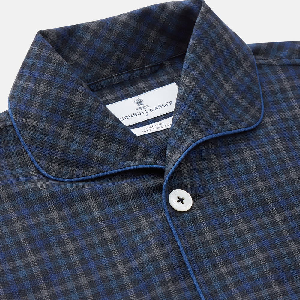 The Turnbull & Asser Blue Multi Check Wool Quin Pyjama Set features a long-sleeve button-up top with chest pocket and drawstring pants, both displayed flat on white—a luxurious choice for refined sleepwear.